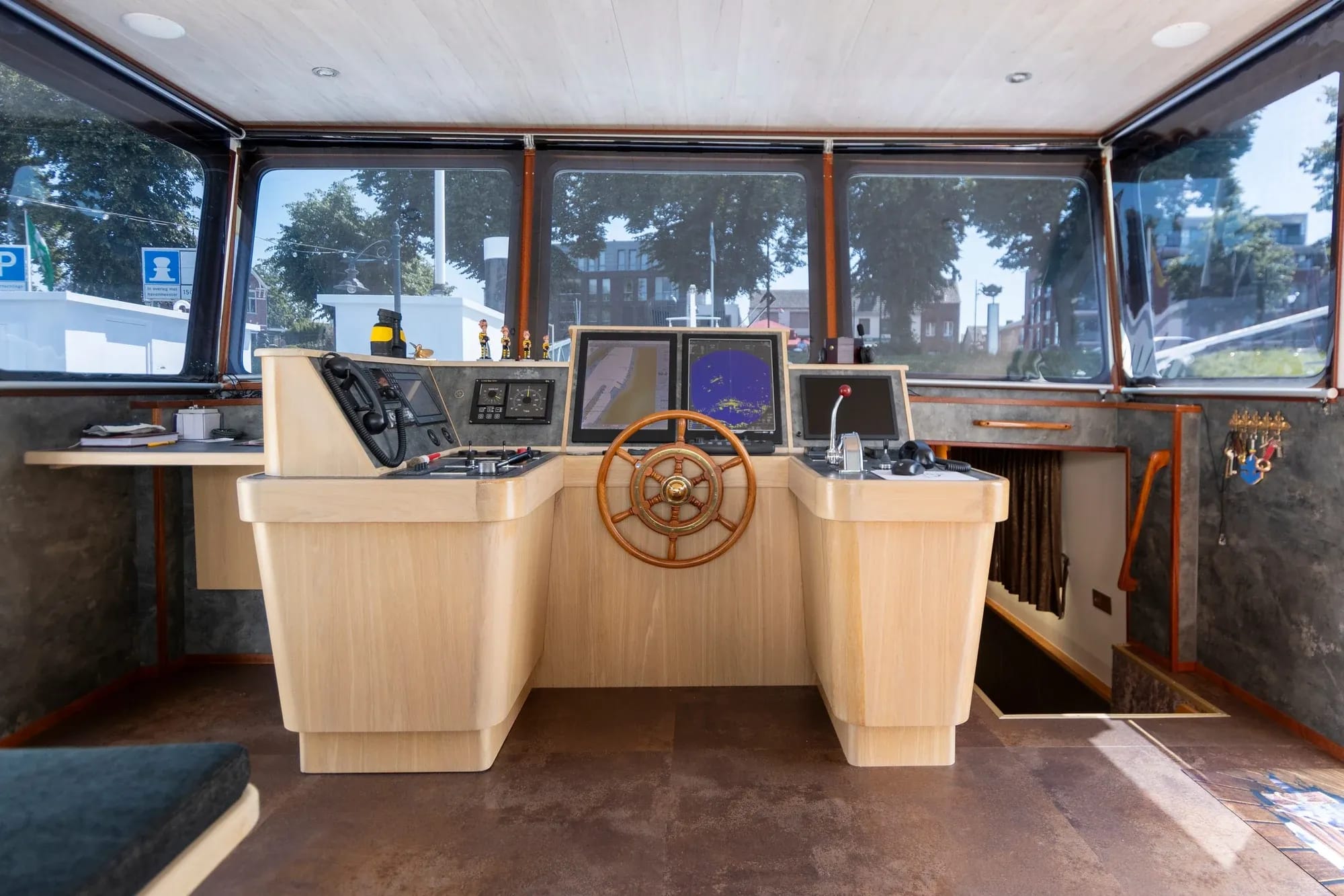 Houten stuurwiel, instrumenten en ramen in de stuurhut van Sadilé.